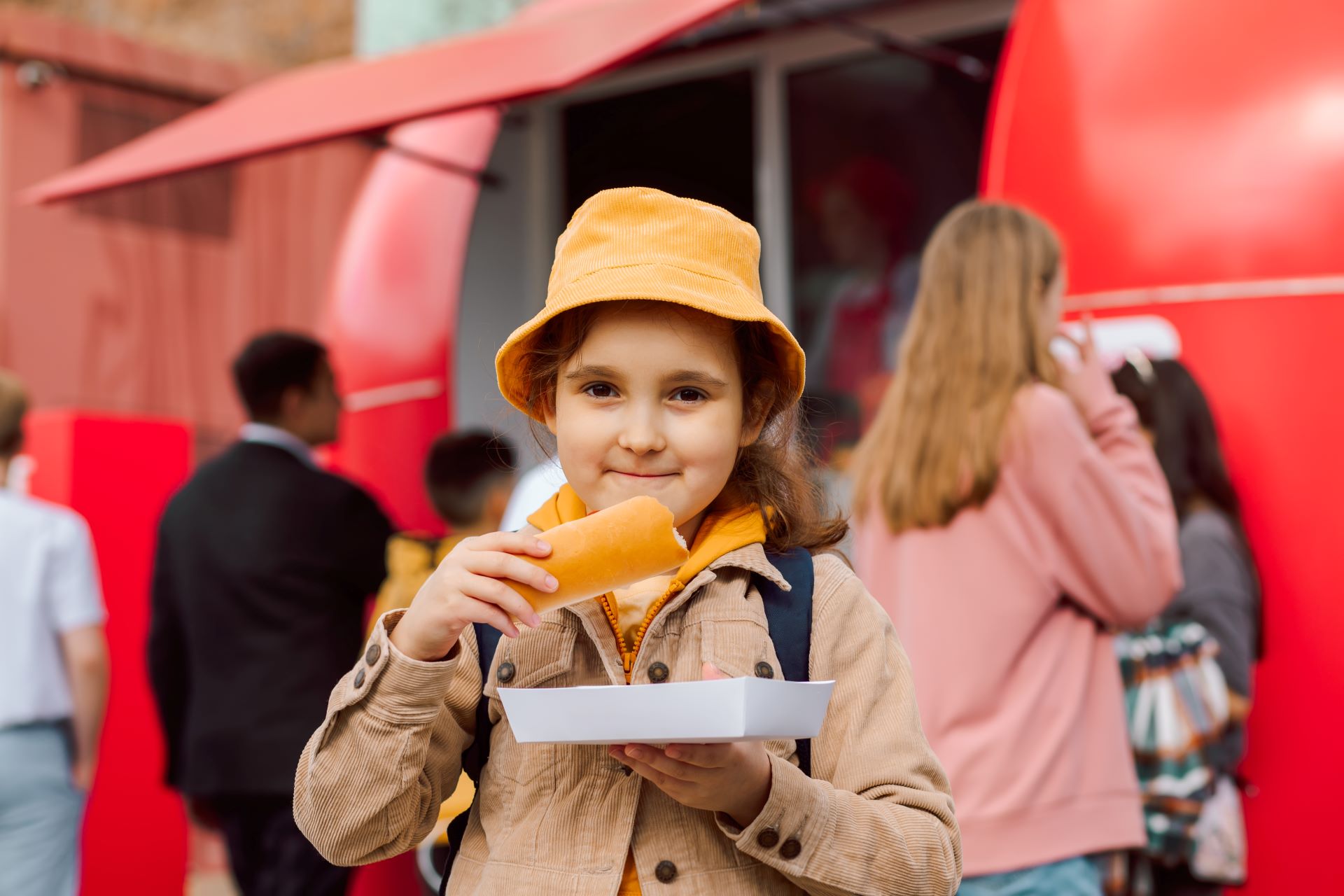 cute-little-girl-eating-hot-dog-nearby-food-track-2024-12-06-03-37-13-utc