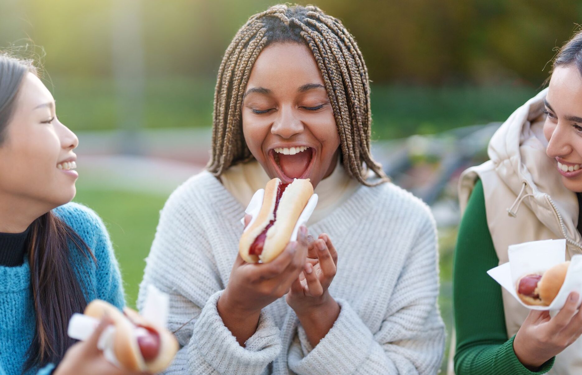 friends-eating-hot-dogs-in-a-park-2025-02-16-05-21-12-utc